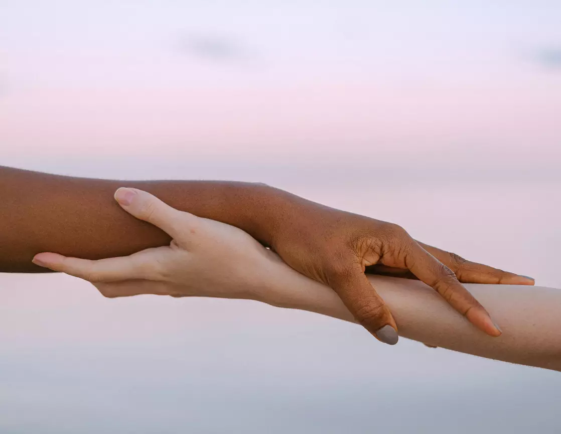 Two hands holding gently, representing emotional support and connection between companions.