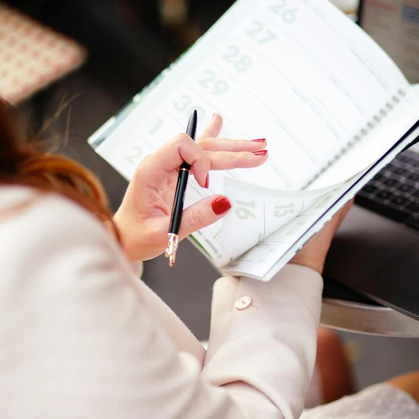 Person holding a planner, representing guided group sessions and patient connection.